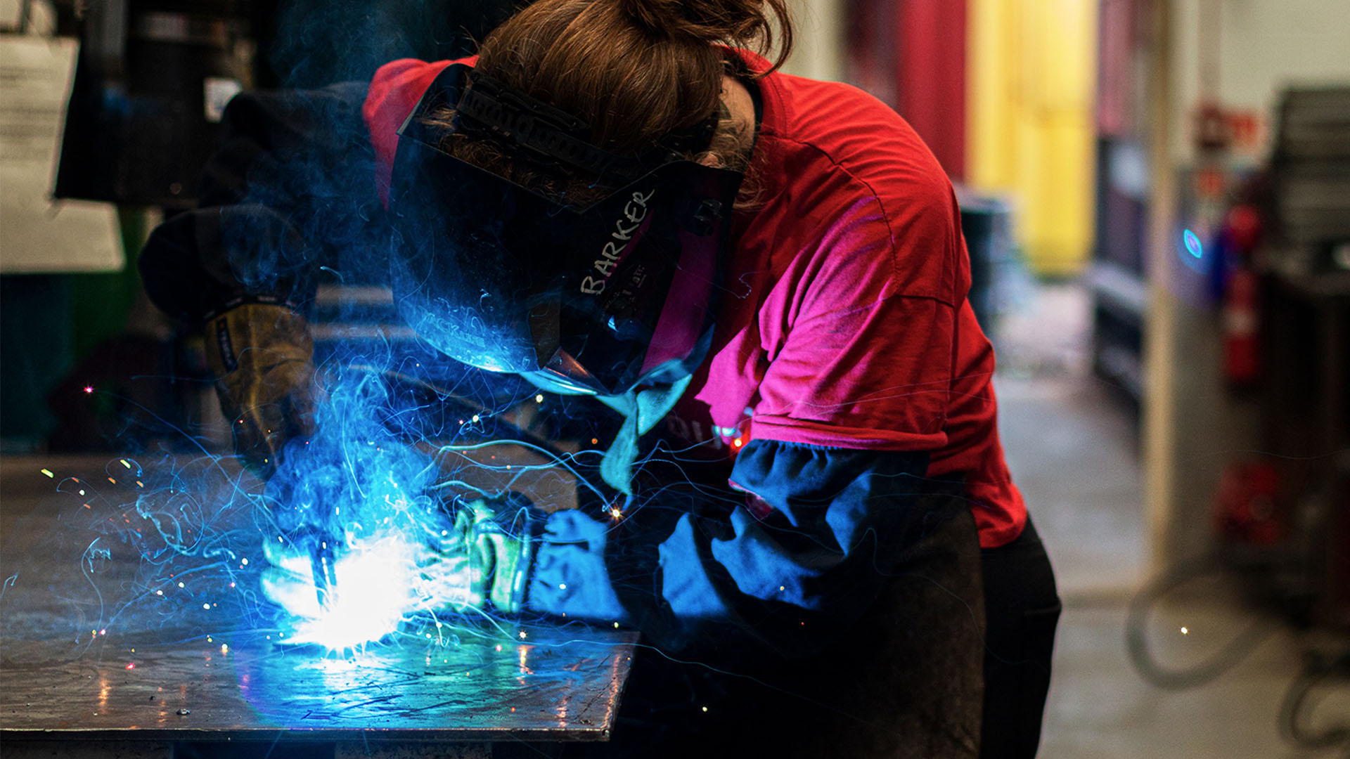 Woman welding in the metal workshop