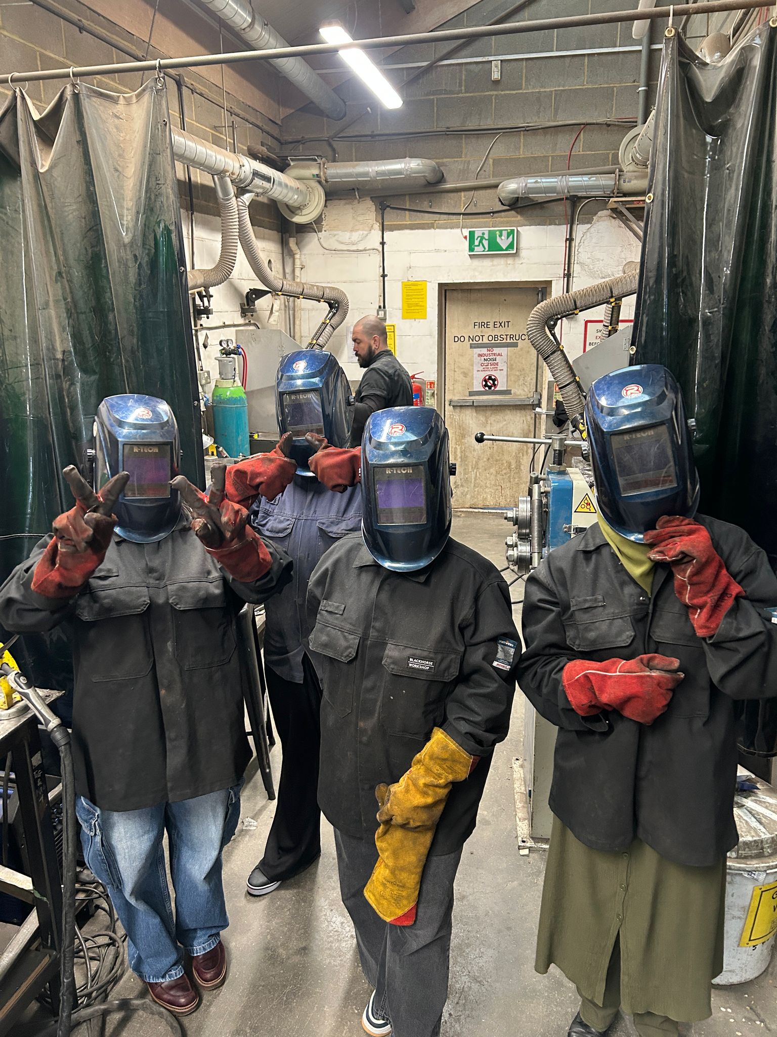 4 young ladies welding, in masks