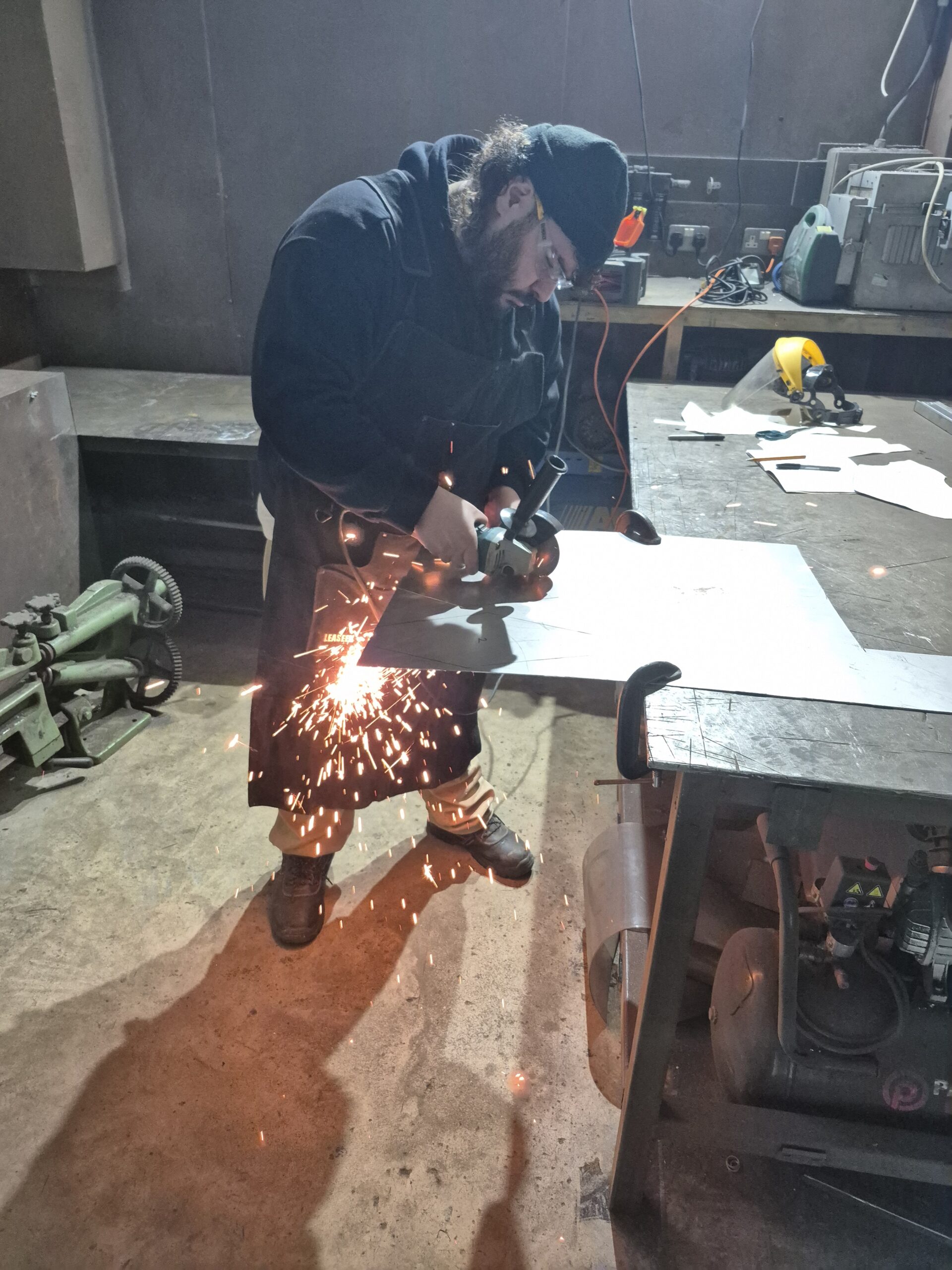 Tutor cutting metal sheet with angle grinder